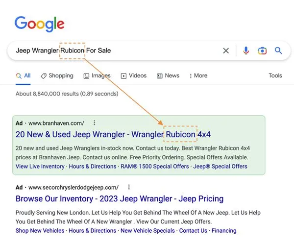 Hand holding phone displaying a Google search for Jeep Wrangler deals